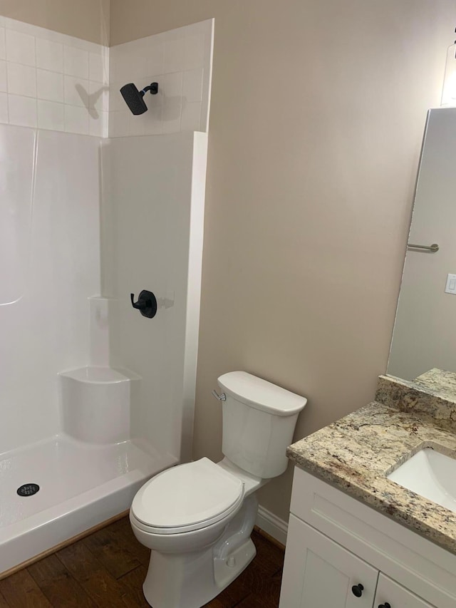 bathroom featuring a shower, toilet, vanity, and wood-type flooring