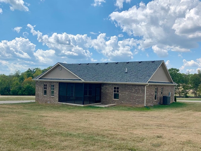 back of property with a yard, a sunroom, and central air condition unit