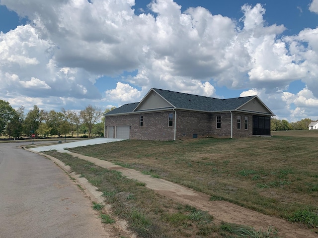 view of side of property featuring a garage and a yard