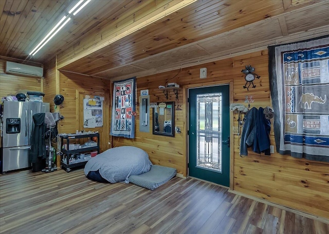 interior space with wood ceiling, wooden walls, wood-type flooring, and a wall mounted air conditioner