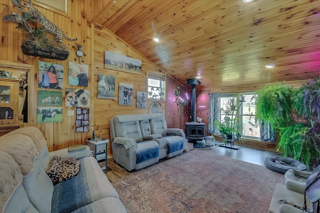 living room with wooden ceiling, lofted ceiling, wood walls, and a wood stove