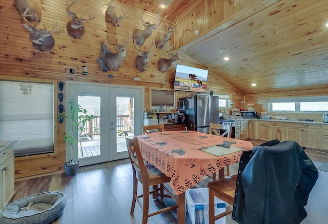 dining area with wood walls, wood-type flooring, french doors, wood ceiling, and lofted ceiling