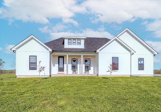 back of house with covered porch and a yard