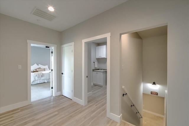 corridor featuring light wood-type flooring and sink