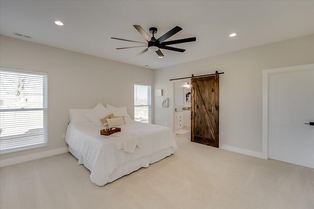 bedroom with carpet flooring, a barn door, multiple windows, and ceiling fan