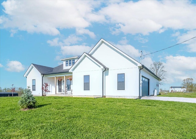 back of property with a yard, a porch, and a garage