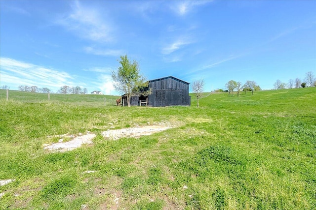 view of yard with a rural view and an outdoor structure