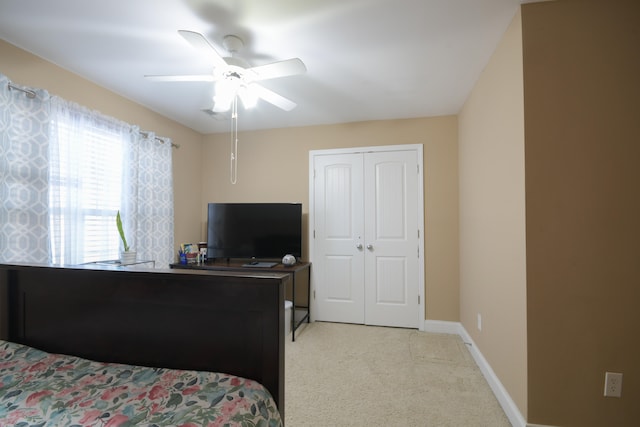 carpeted bedroom with ceiling fan and a closet