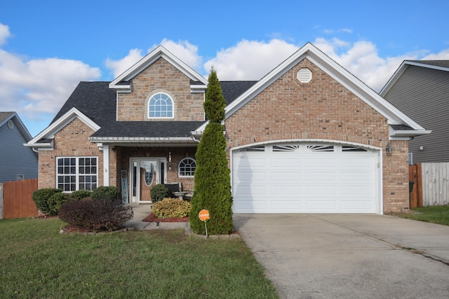 view of property with a garage and a front lawn