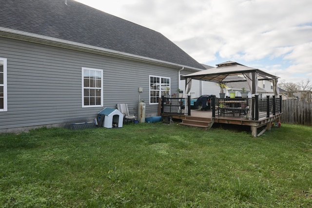 back of property with a gazebo, a lawn, and a wooden deck