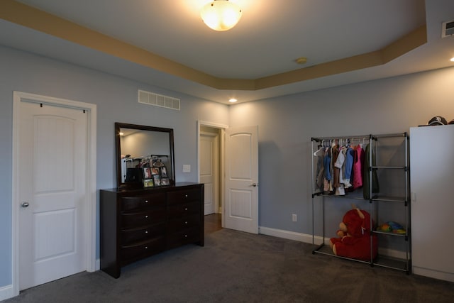 carpeted bedroom with a raised ceiling