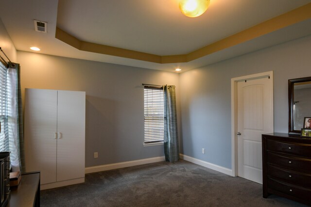 carpeted bedroom with a tray ceiling