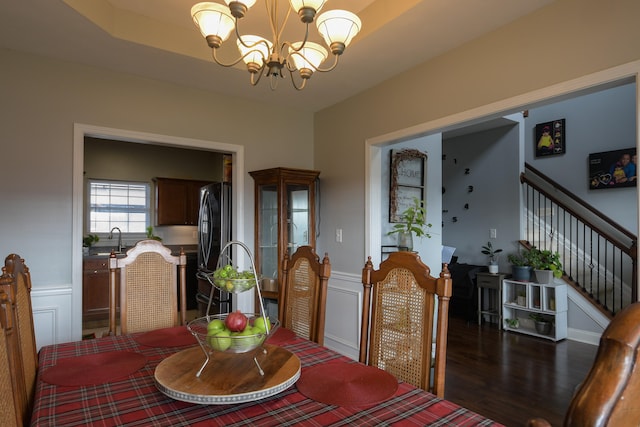 dining room with dark hardwood / wood-style flooring, sink, and an inviting chandelier