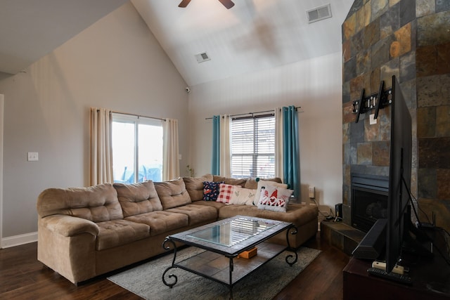 living room featuring ceiling fan, dark hardwood / wood-style flooring, a tile fireplace, and high vaulted ceiling