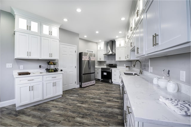 kitchen with light stone countertops, white cabinetry, sink, wall chimney exhaust hood, and stainless steel appliances