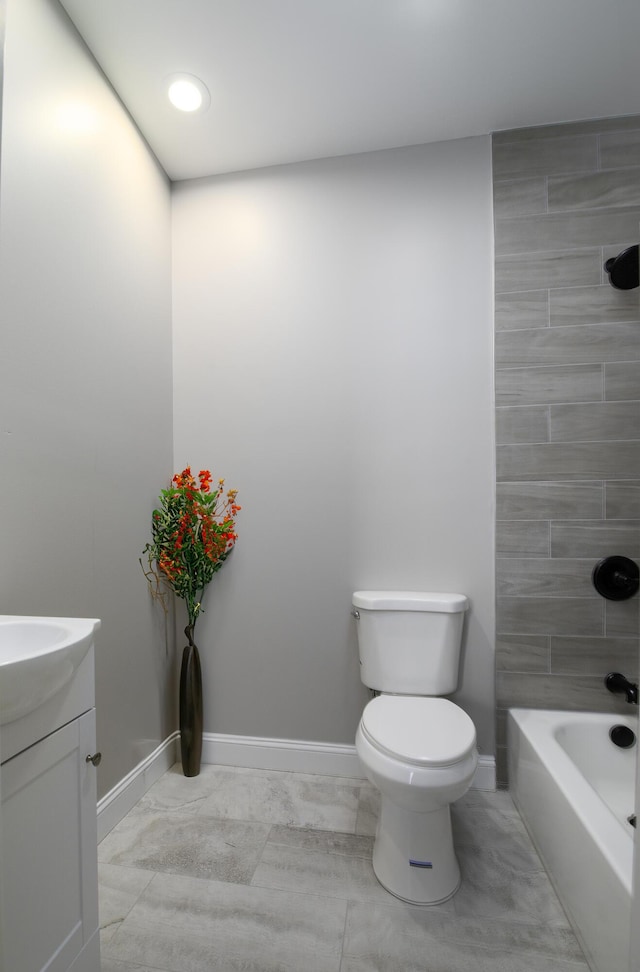 full bathroom with vanity, tiled shower / bath combo, and toilet