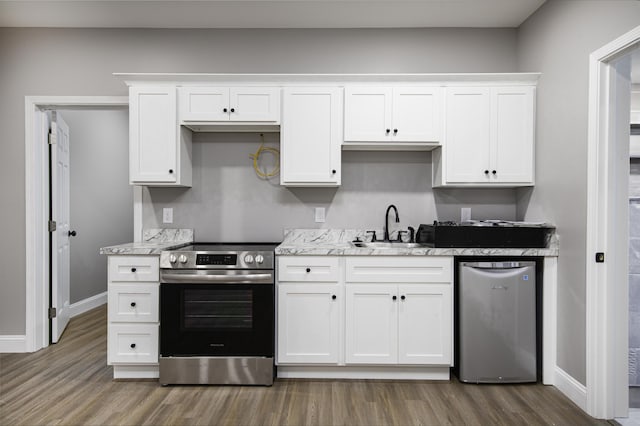 kitchen featuring stainless steel range with electric stovetop, white cabinetry, and sink