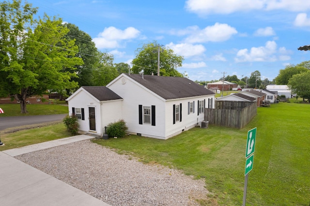 view of home's exterior with a yard, driveway, central AC unit, and roof with shingles