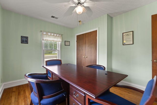 office area featuring visible vents, baseboards, ceiling fan, and wood-type flooring