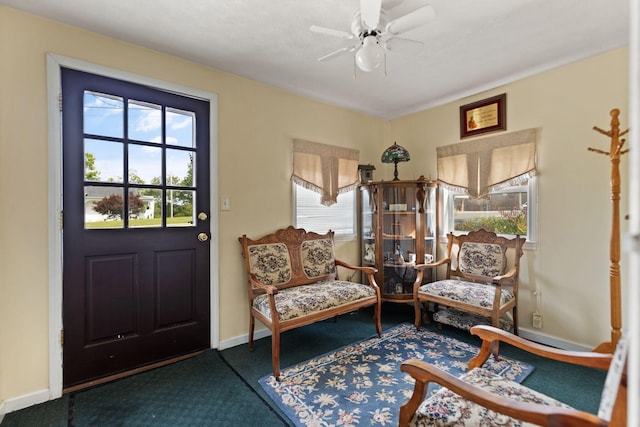 living area featuring carpet flooring, ceiling fan, plenty of natural light, and baseboards