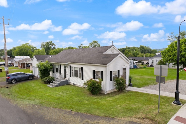 bungalow-style house with driveway, a front yard, roof with shingles, a residential view, and an attached garage