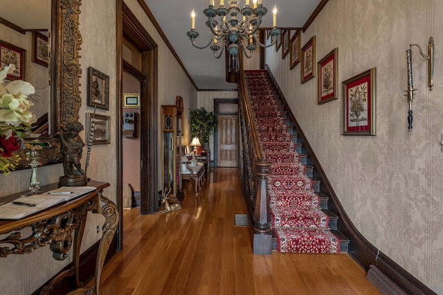 1023 Riverside Dr, Greenup, KY 41144 - staircase with ornamental molding, wood finished floors, wallpapered walls, and a chandelier