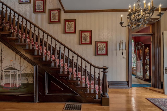 1023 Riverside Dr, Greenup, KY 41144 - stairway with a chandelier, wood finished floors, wallpapered walls, and ornamental molding