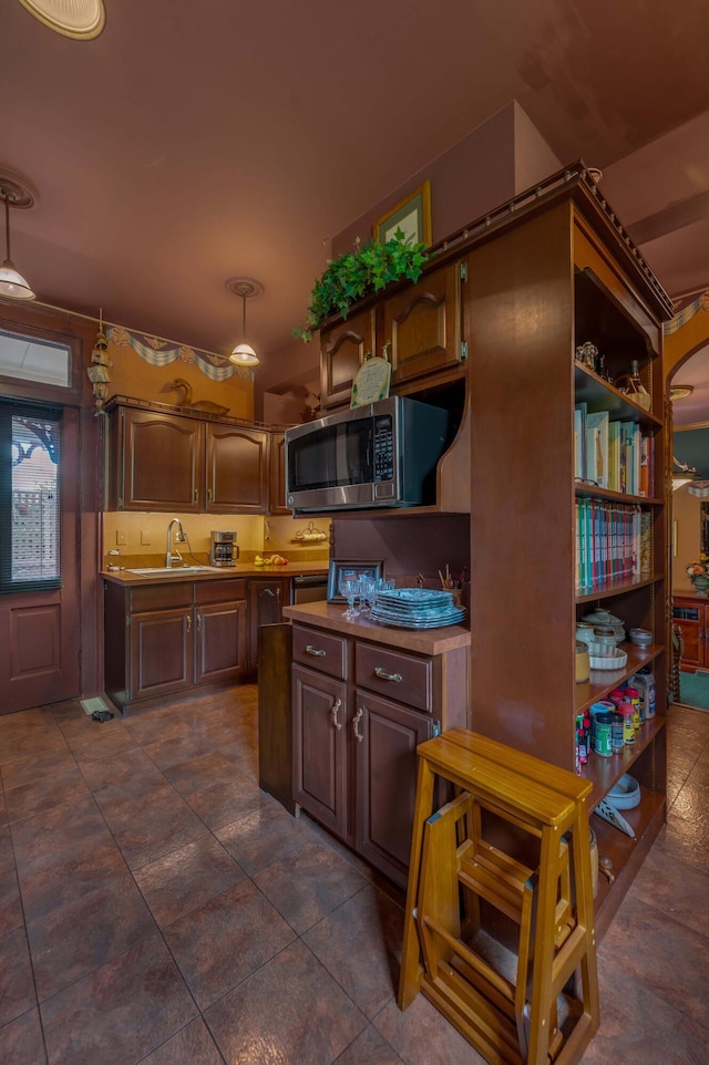 1023 Riverside Dr, Greenup, KY 41144 - kitchen featuring stainless steel microwave, a sink, open shelves, and dark tile patterned flooring