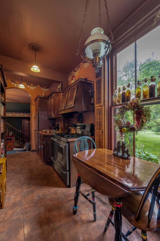 1023 Riverside Dr, Greenup, KY 41144 - kitchen with appliances with stainless steel finishes, custom exhaust hood, healthy amount of natural light, and dark tile patterned flooring