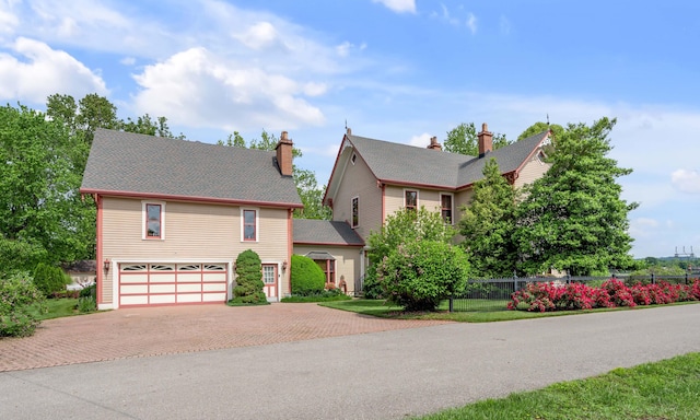1023 Riverside Dr, Greenup, KY 41144 - view of front of property featuring decorative driveway, an attached garage, fence, and a chimney