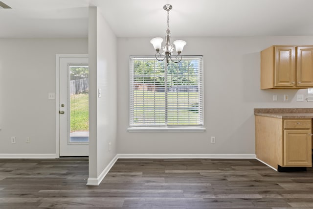 unfurnished dining area with baseboards, a chandelier, and dark wood-style flooring