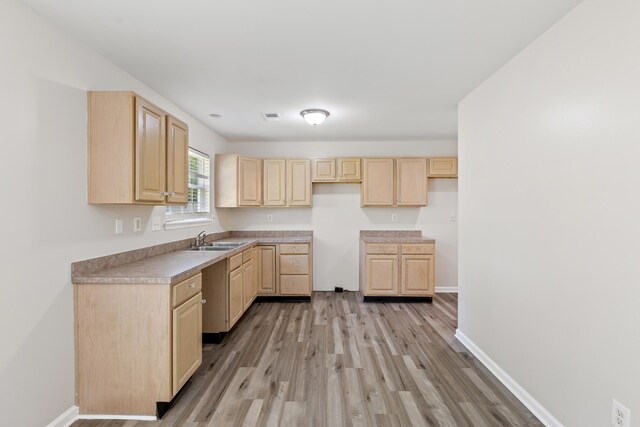 kitchen with visible vents, baseboards, light wood-style flooring, light brown cabinetry, and a sink