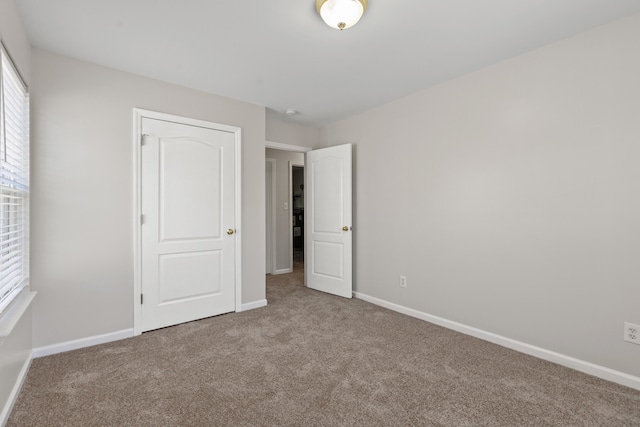 unfurnished bedroom with carpet and baseboards