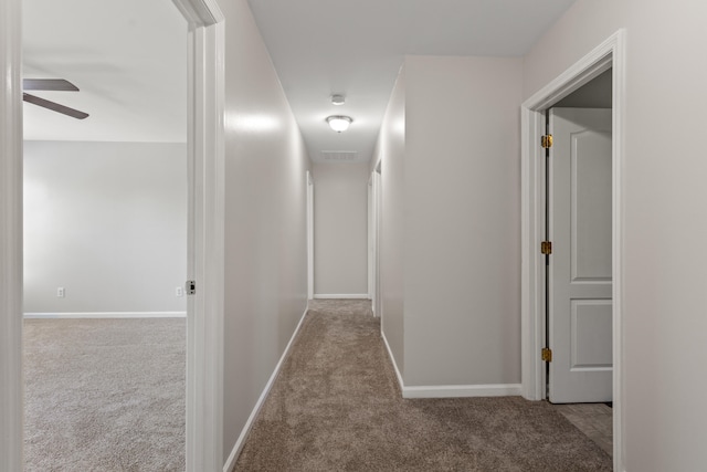 corridor featuring carpet, visible vents, and baseboards