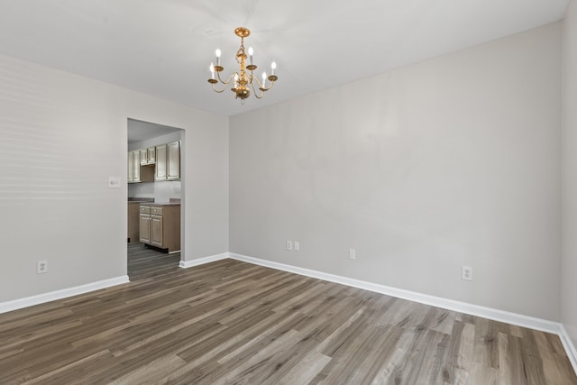 interior space featuring baseboards, a chandelier, and dark wood finished floors