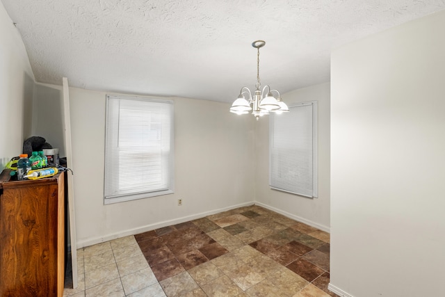 858 Lylesville St, Paris, KY 40361 - unfurnished dining area with a chandelier, baseboards, a textured ceiling, and stone finish flooring