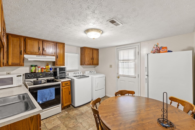 858 Lylesville St, Paris, KY 40361 - kitchen featuring white appliances, separate washer and dryer, under cabinet range hood, brown cabinets, and a textured ceiling