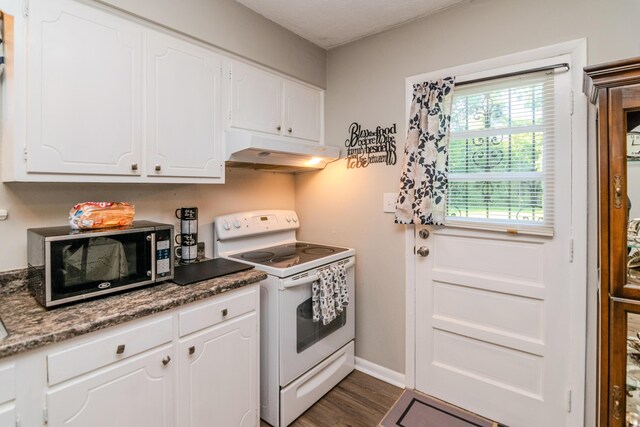 kitchen with dark hardwood / wood-style floors, white cabinetry, dark stone counters, and electric stove