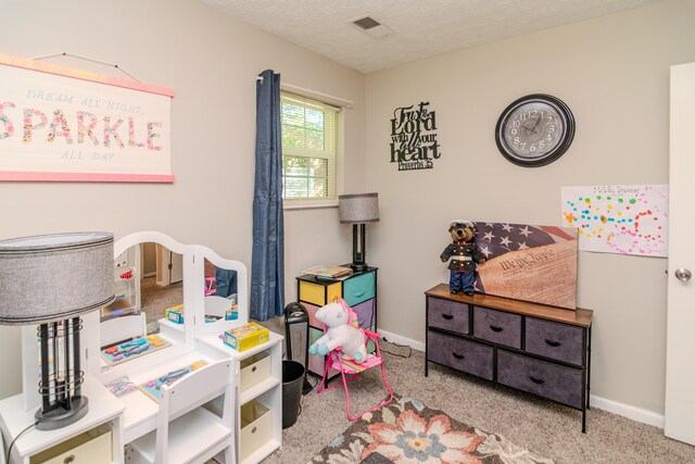 game room with a textured ceiling and light colored carpet