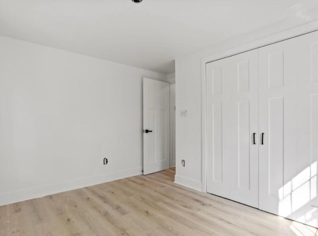 unfurnished bedroom with a closet and light hardwood / wood-style flooring