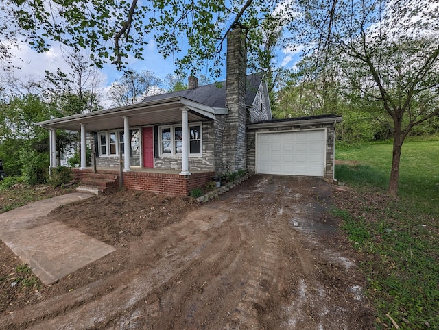 view of front of home featuring a garage, a front yard, and covered porch