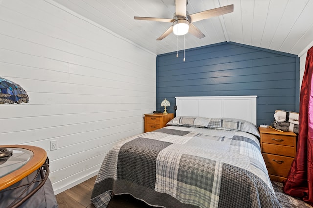 bedroom featuring wooden walls, dark hardwood / wood-style floors, ceiling fan, and lofted ceiling