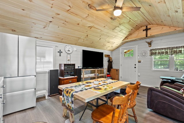 dining room featuring plenty of natural light, wood walls, lofted ceiling, and wood ceiling