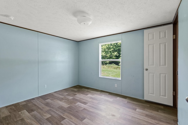 spare room featuring hardwood / wood-style floors and a textured ceiling