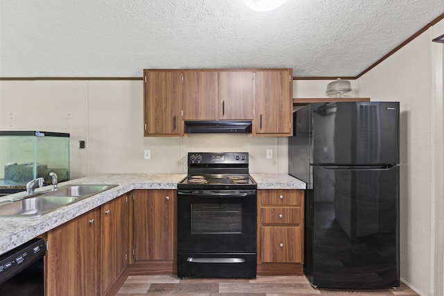 kitchen featuring black appliances, crown molding, sink, hardwood / wood-style flooring, and a textured ceiling