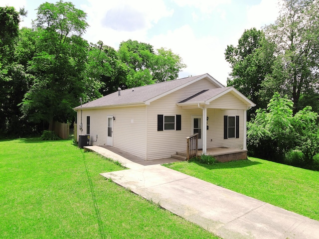 rear view of property with a yard, a patio area, a storage unit, and cooling unit