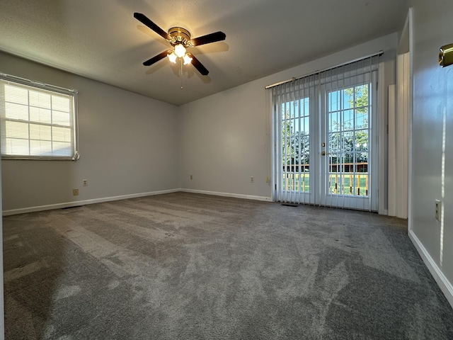 unfurnished room featuring ceiling fan, dark colored carpet, and baseboards