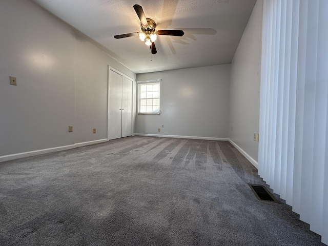 unfurnished room with carpet floors, visible vents, a ceiling fan, a textured ceiling, and baseboards