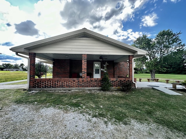 bungalow-style home with a porch, a front yard, and brick siding