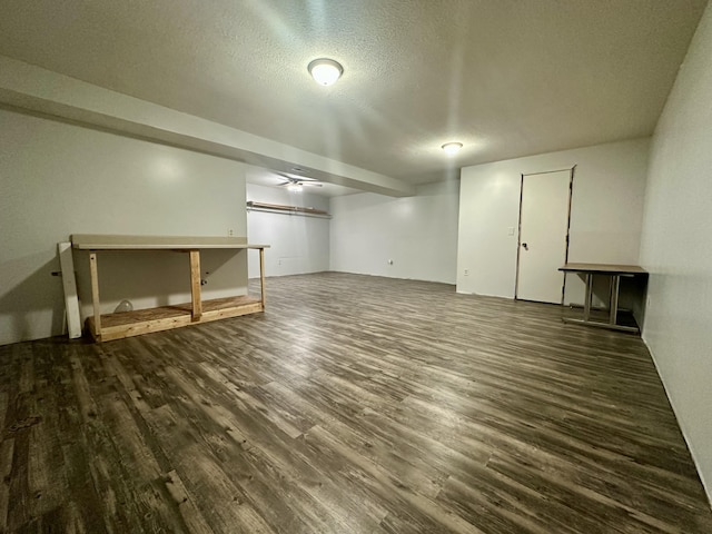 finished basement with a textured ceiling and dark wood-type flooring